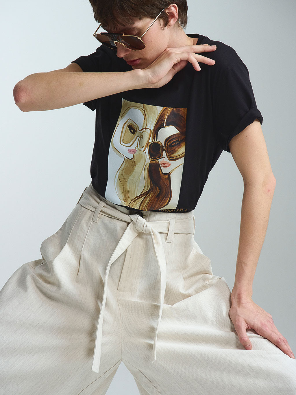 Ein besonders detailreiches Statement-Piece: Das limitierte RAILIN x Astrid Vos X T-Shirt in Schwarz setzt den kunstvollen Print perfekt in Szene. Ein exklusives Sammlerstück aus hochwertigen Künstler Edits, getragen mit einer beigen Bundfaltenhose.
